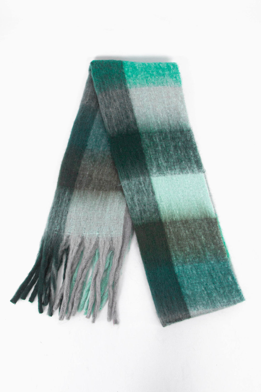showing the scarf folded while laying flat, the green and teal square block pattern is highlighted.