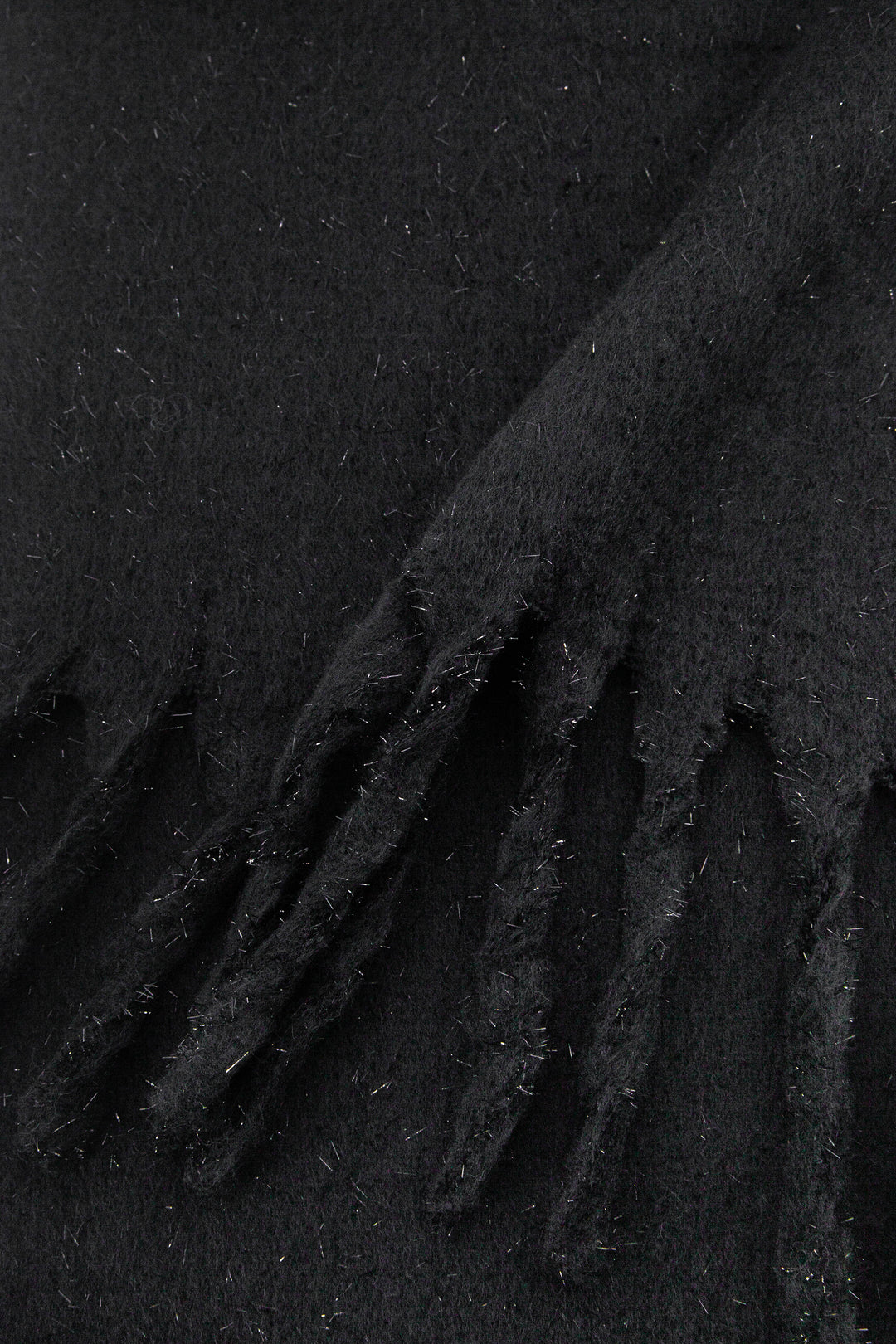 close up of the knitted material of the winter blanket scarf, the silver tinsel fibres are clearly shown