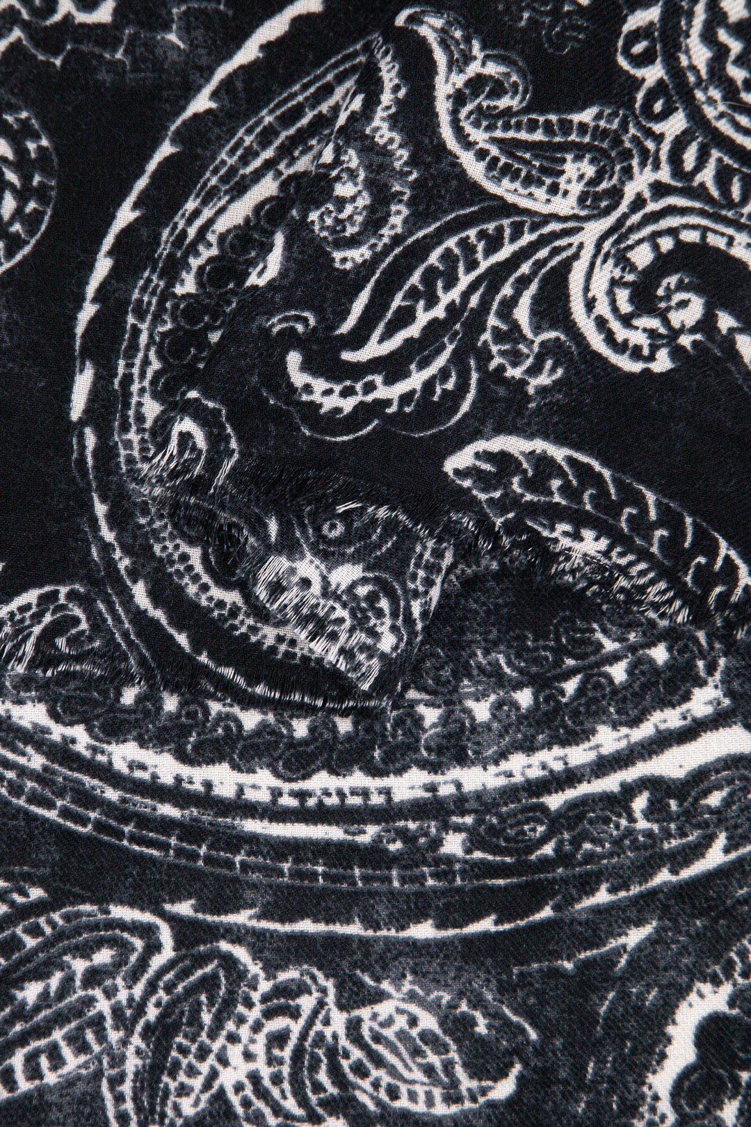 close up of the soft viscose fabric, the black and white paisley floral design is visible