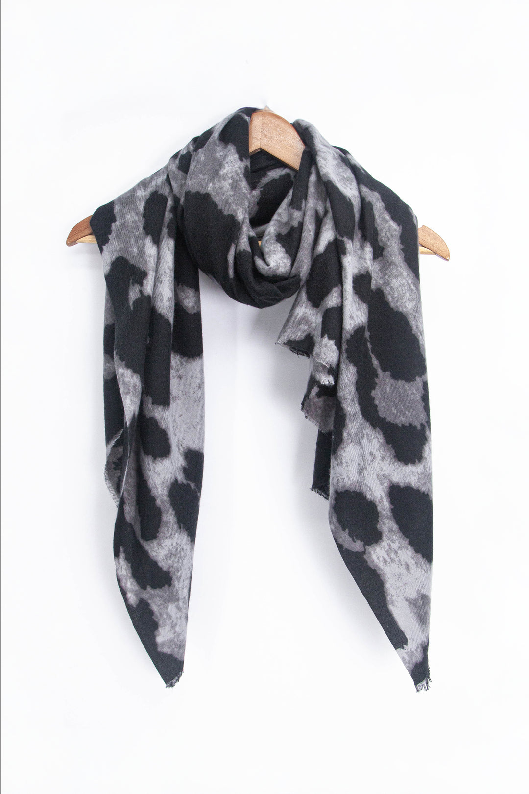 showing the scarf draped around a coat hanger, showing the all over pattern and how it would look when worn