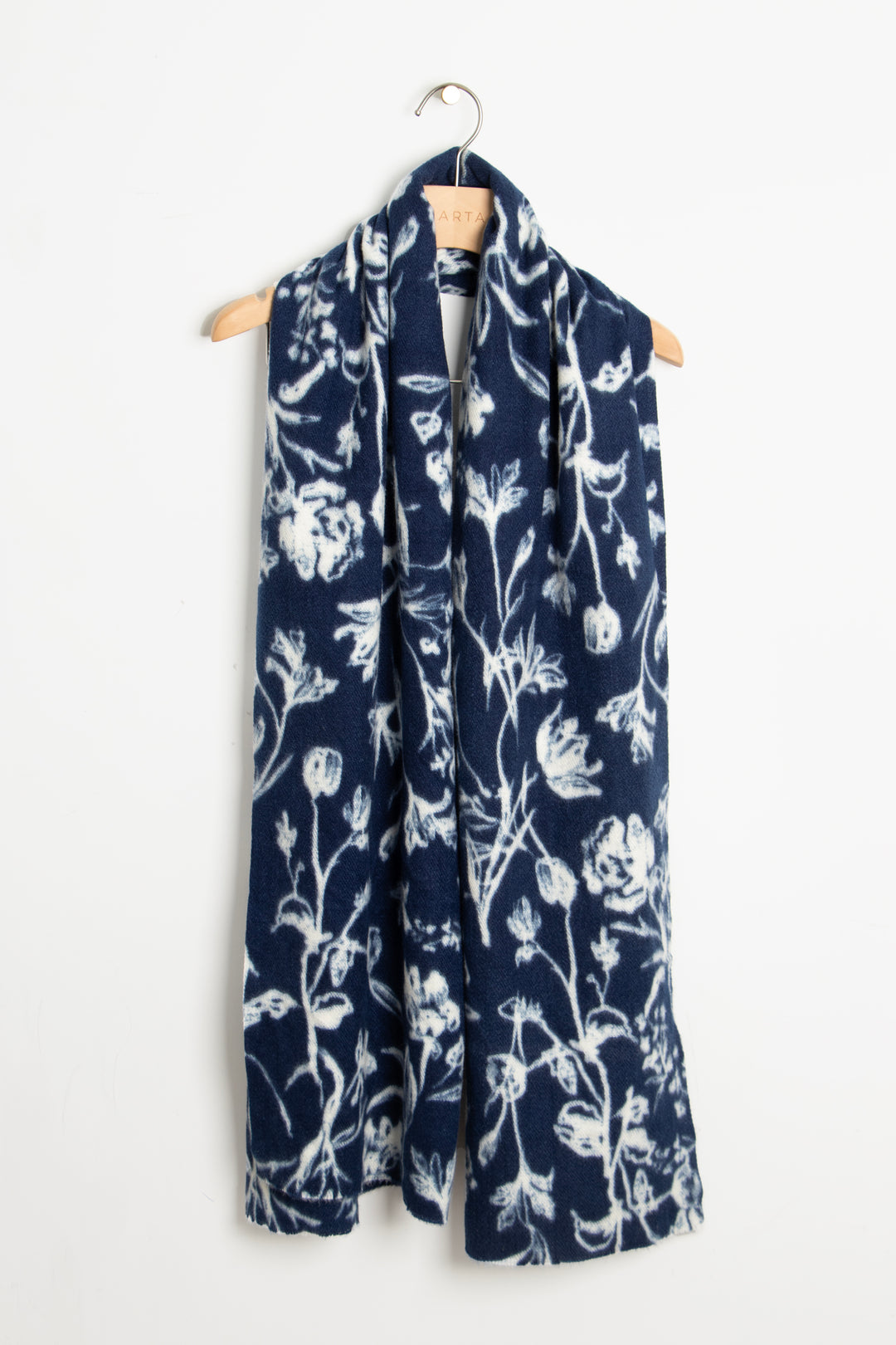 showing the scarf draped around a coat hanger, showing the all over pattern and how it would look when worn