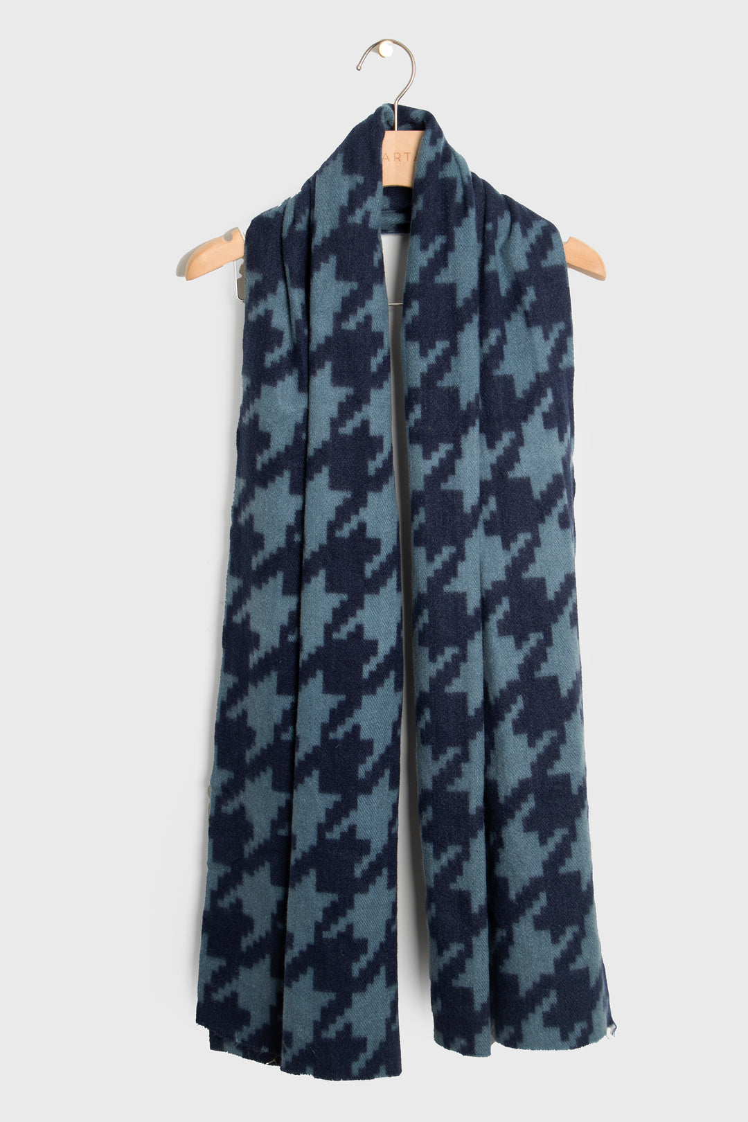 showing the scarf draped around a coat hanger, showing the all over pattern and how it would look when worn