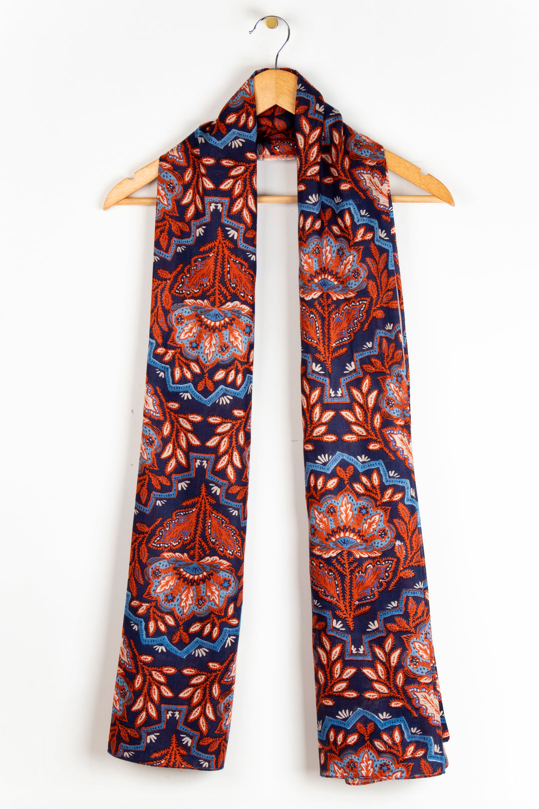 showing the scarf draped around a coat hanger, showing the all over pattern and how it would look when worn