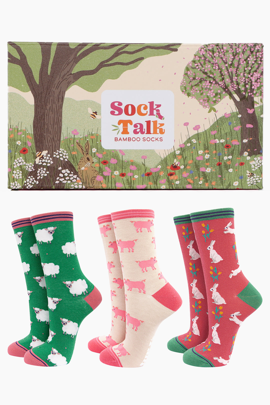 an artistically designed sock gift box designed to look like a summer woodland meadow with three pairs of ladies bamboo ankle socks featuring spring farm animals, pig, lambs and rabbits