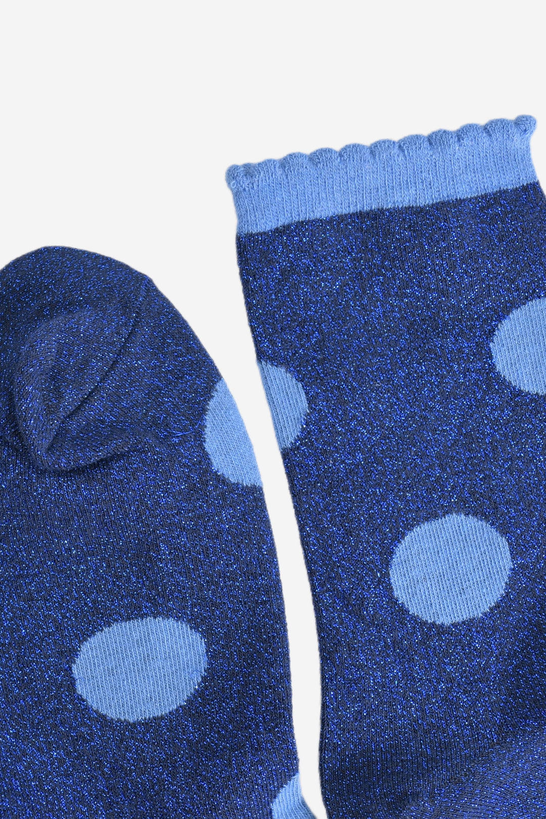 showing the toe and cuff of the socks, the toe is dark blue glitter in keeping with the base of the socks, the cuff is light blue like the polka dots and has a frilled scalloped edge
