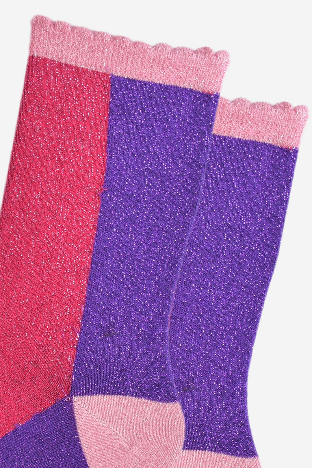 close up of the fuchsia and purple colour block pattern on the socks, both colours have an all over silver glitter sparkle