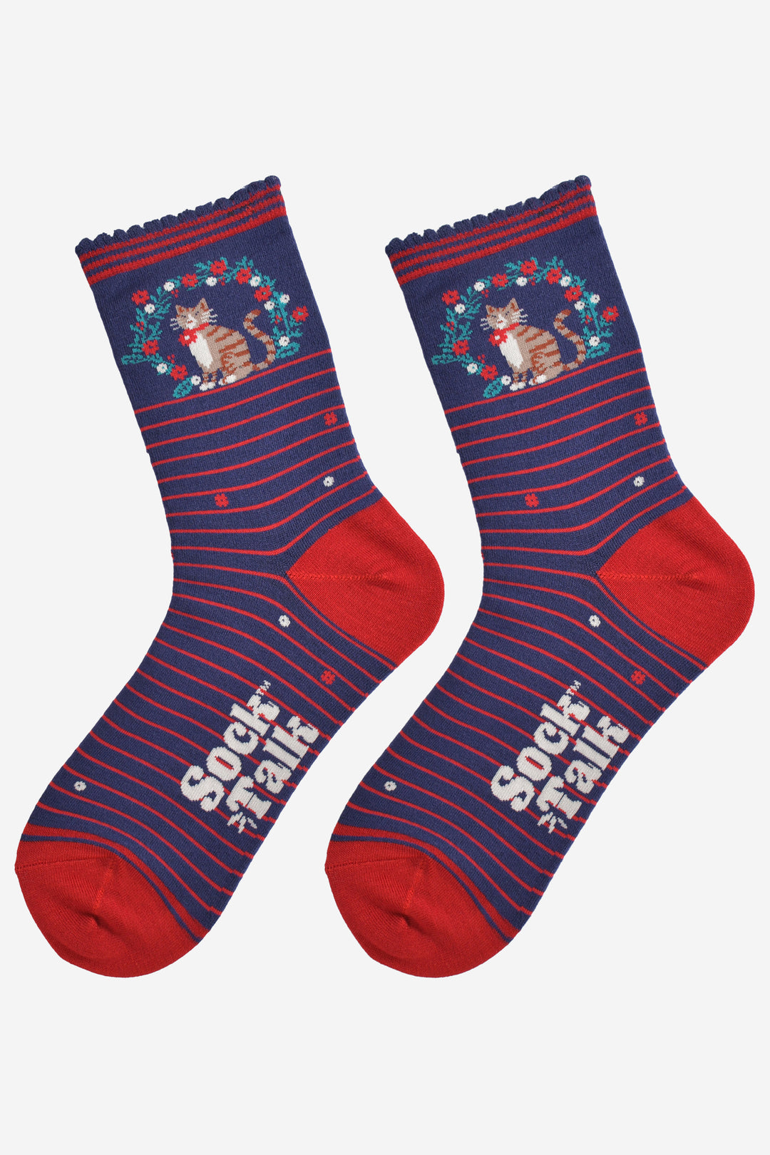 showing the socks laying flat, the striped pattern in prominent and punctuated with red and white flowers. the cat and wreath pattern on the ankle of the socks