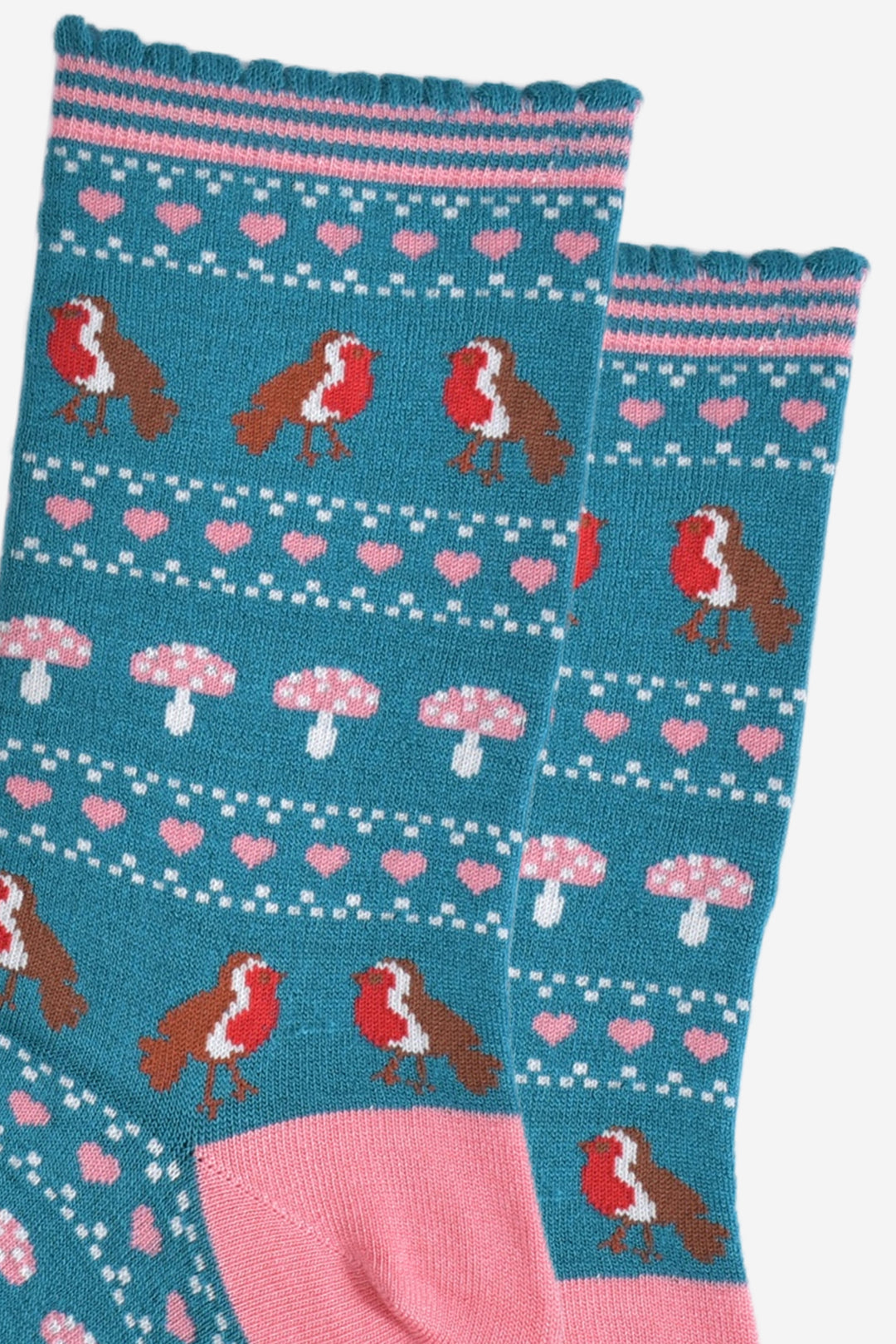 close up of the fair isle pattern, there are red robin birds, pink love hearts and pink toadstools in rows all separated by small white dots