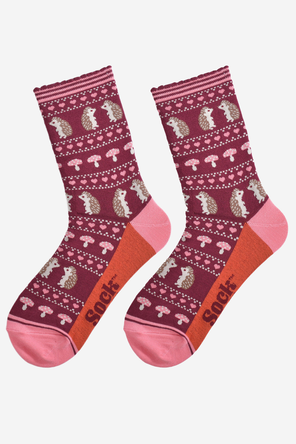 showing the fair isle hedgehog socks laying flat, highlighting the all over pattern featuring hedgehogs, toadstools and pink love hearts