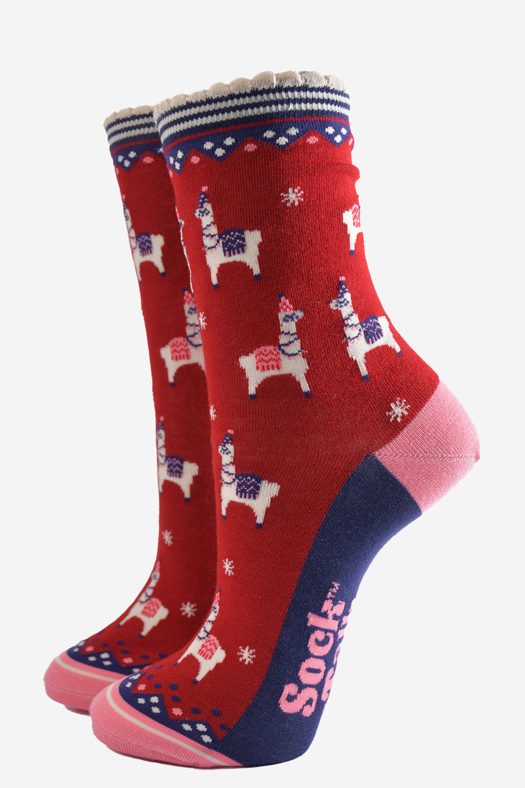 red bamboo socks with a navy striped cuff featuring a pattern of llamas wearing party hats and party lights