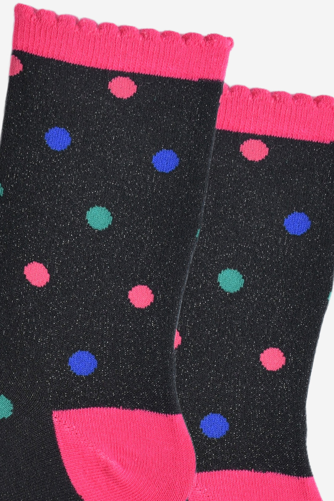 close up of the polka dot pattern, there are hot pink, royal blue and teal blue spots all over the socks