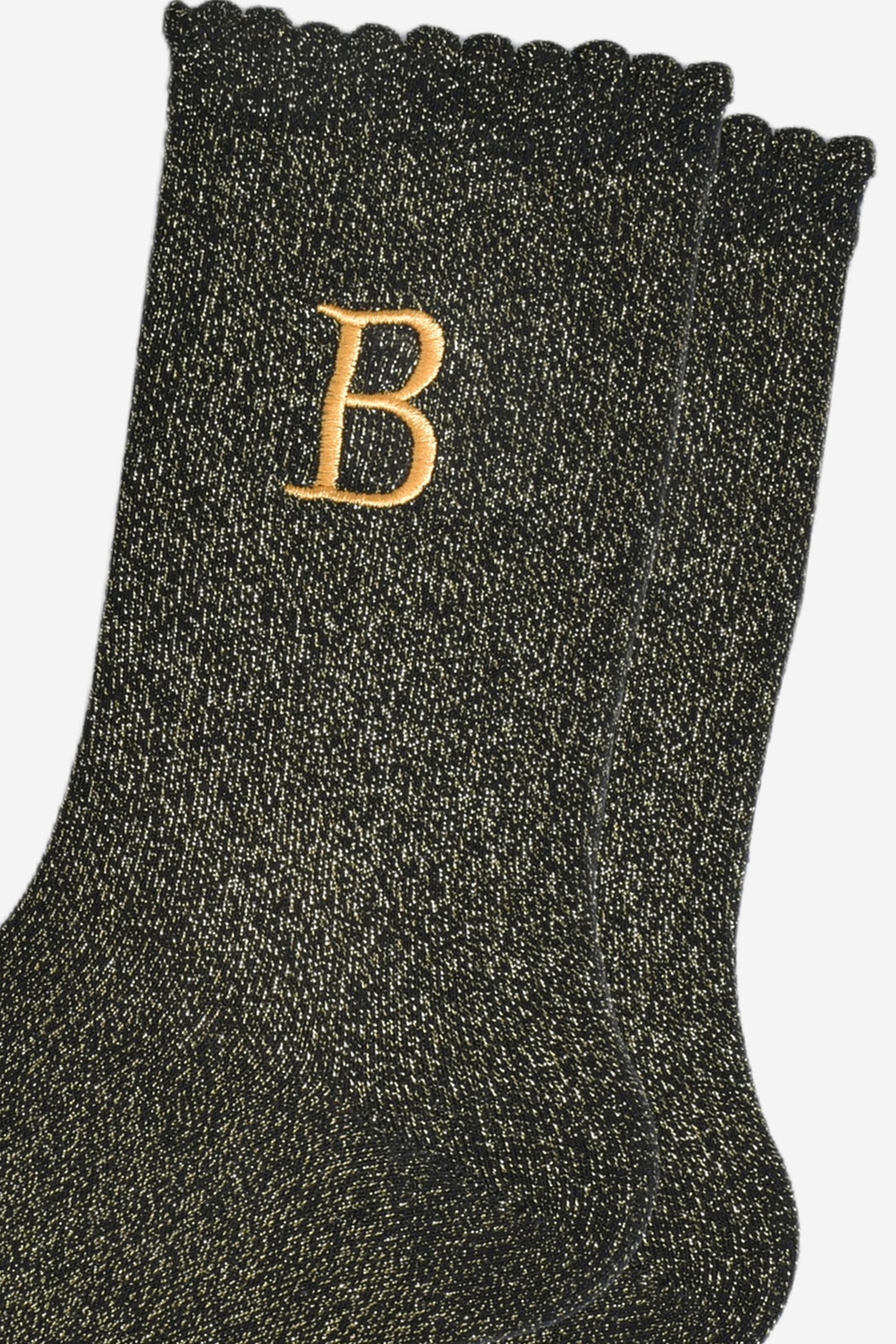 close up of the gold embroidered capital letter b on the ankle of the socks