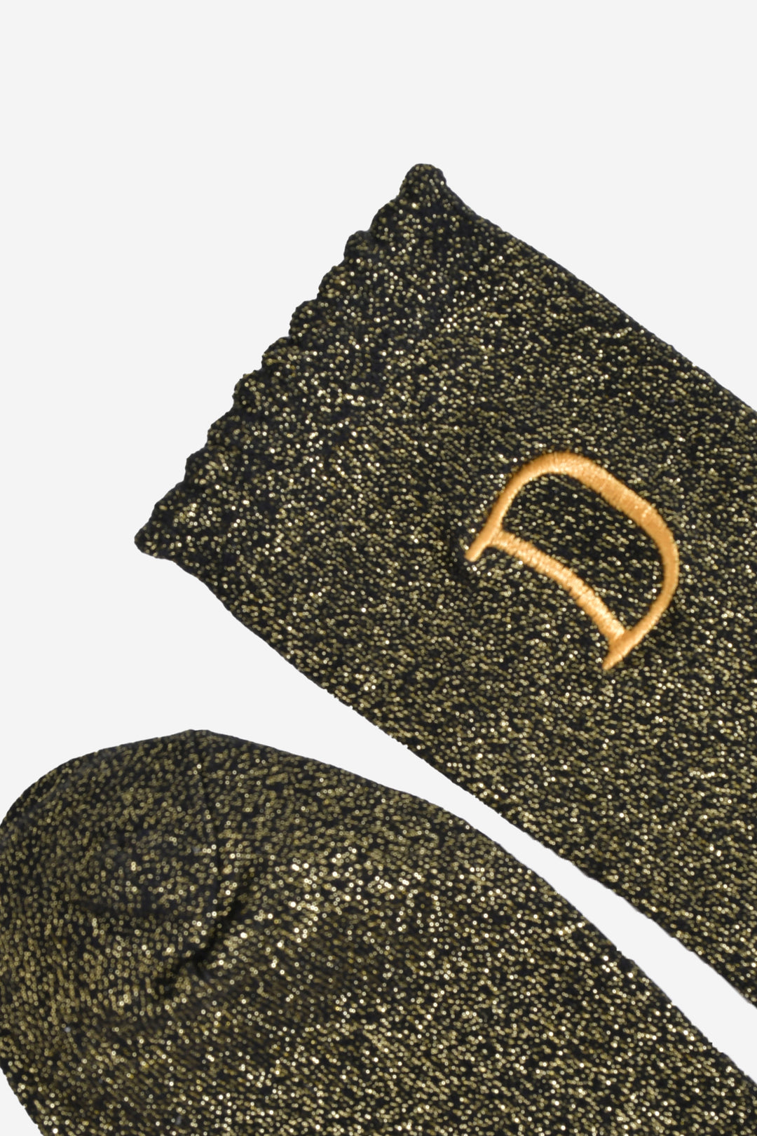 close up of the scalloped cuff on the socks, the toe is the same black and gold as the rest of the socks