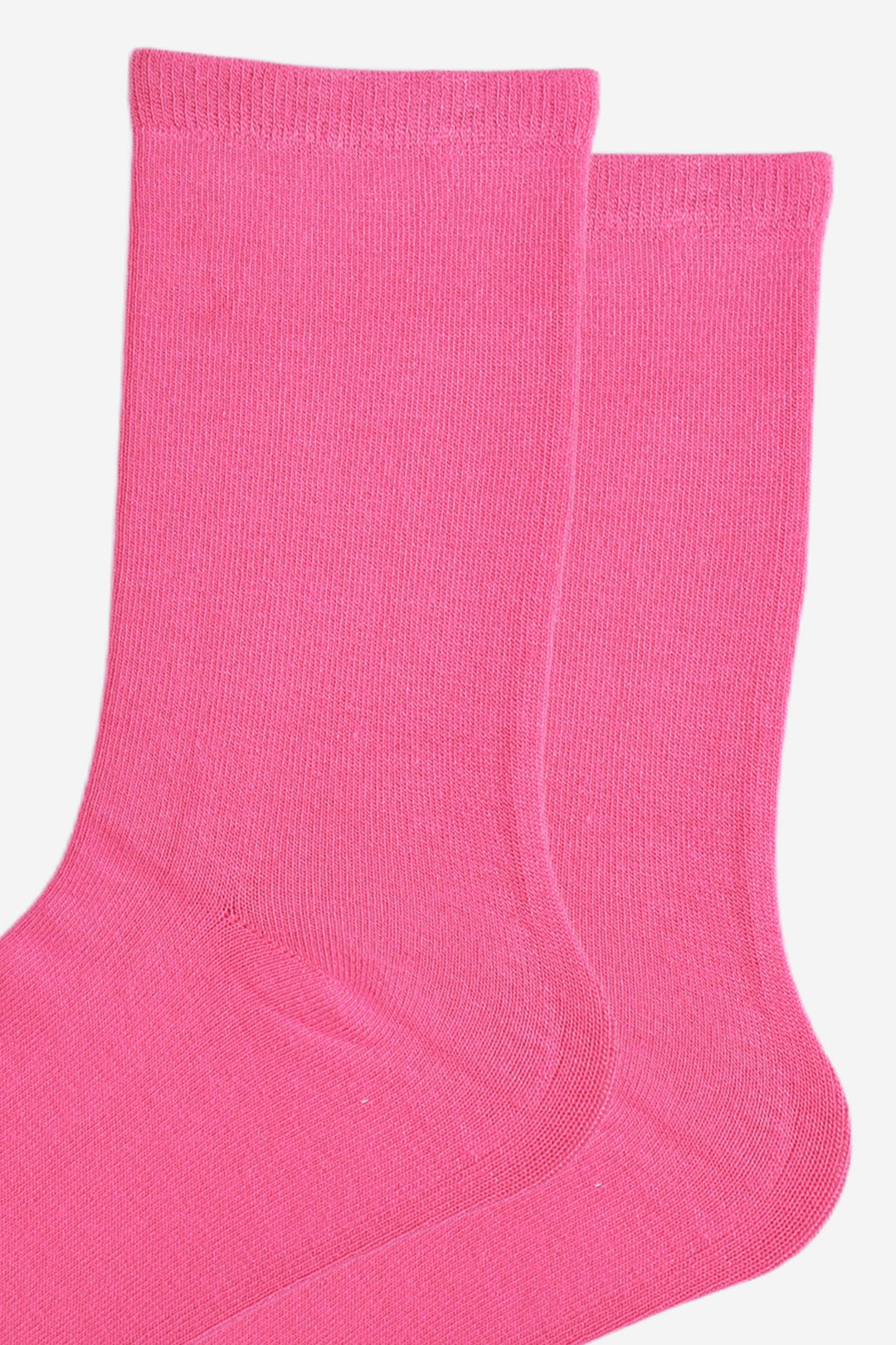 close up of the socks, showing the plain hot pink colour and the classic straight cuff