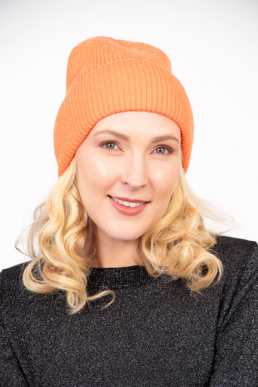 model wearing a plain orange ribbed beanie knitted hat