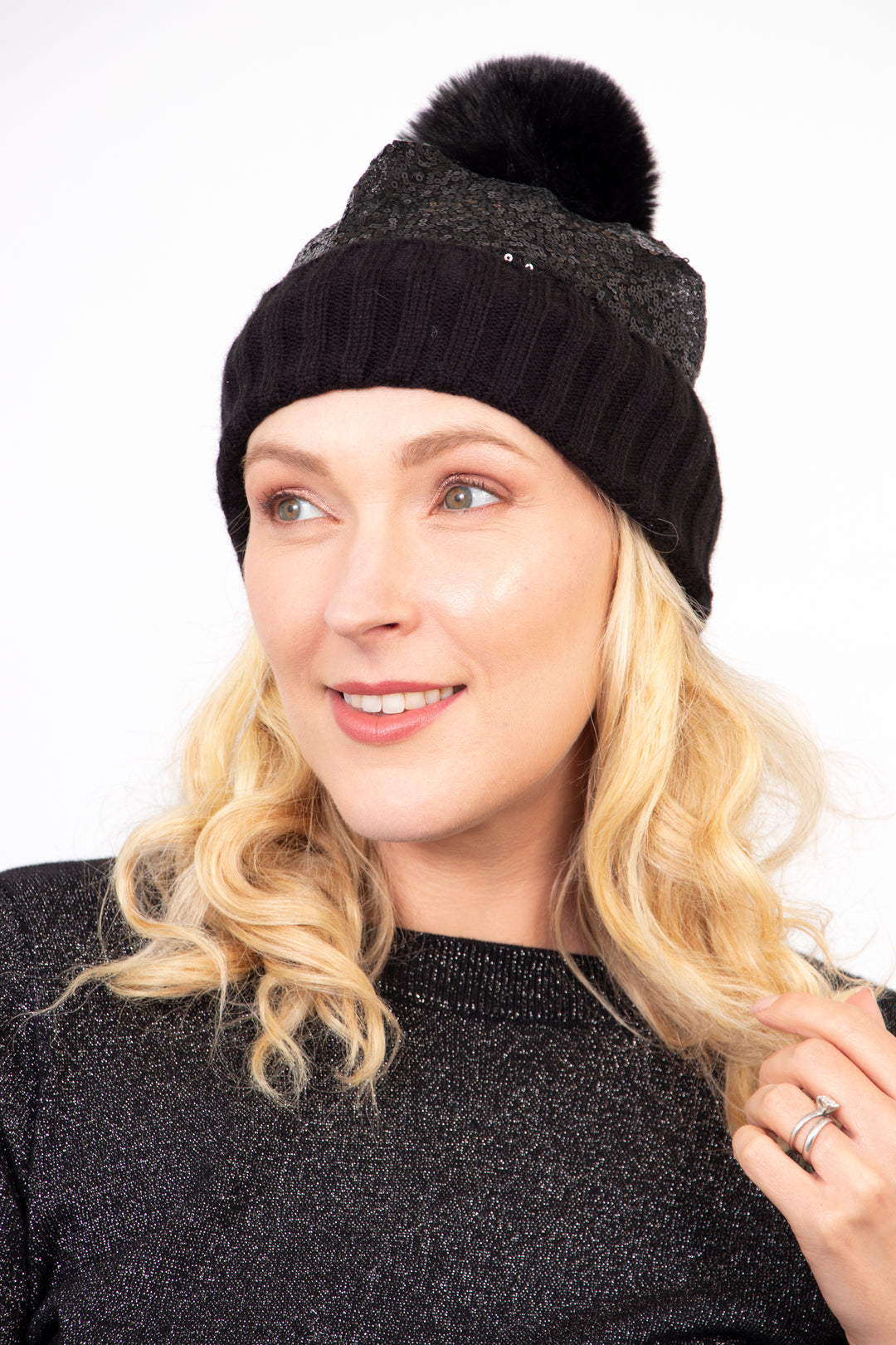 model wearing a black hat with a pom pom and black sequin
