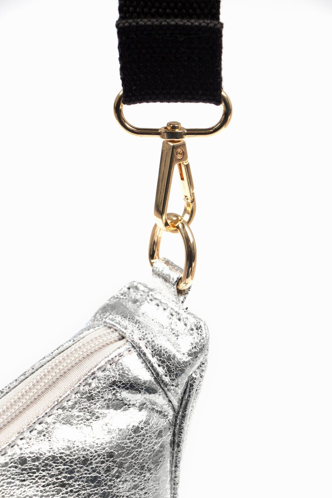 close up of the gold coloured snap hook attachment on the end of the bag strap, showing how it connects to the bag