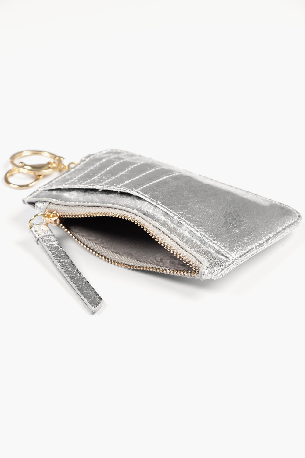 showing the silver card holder laying flat, there is an open zip pocket compartment, also showing are the card slots on the outside of the item