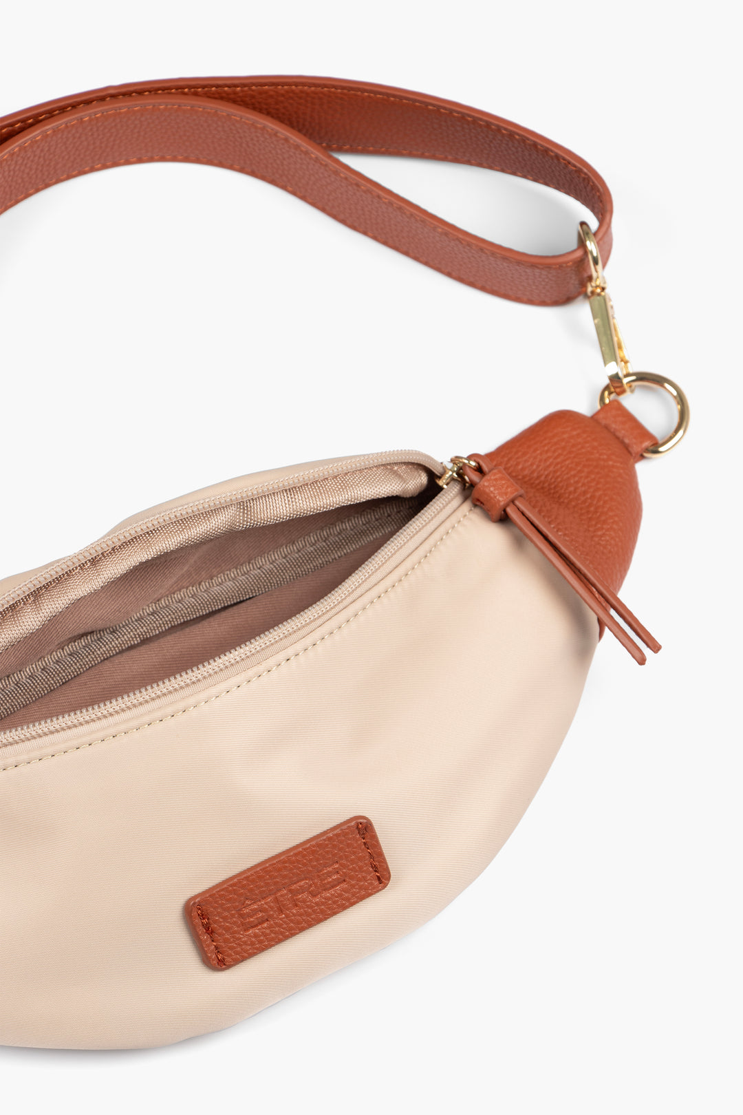 close up of the open bum bag showing also the tan faux leather strap and gold hardware