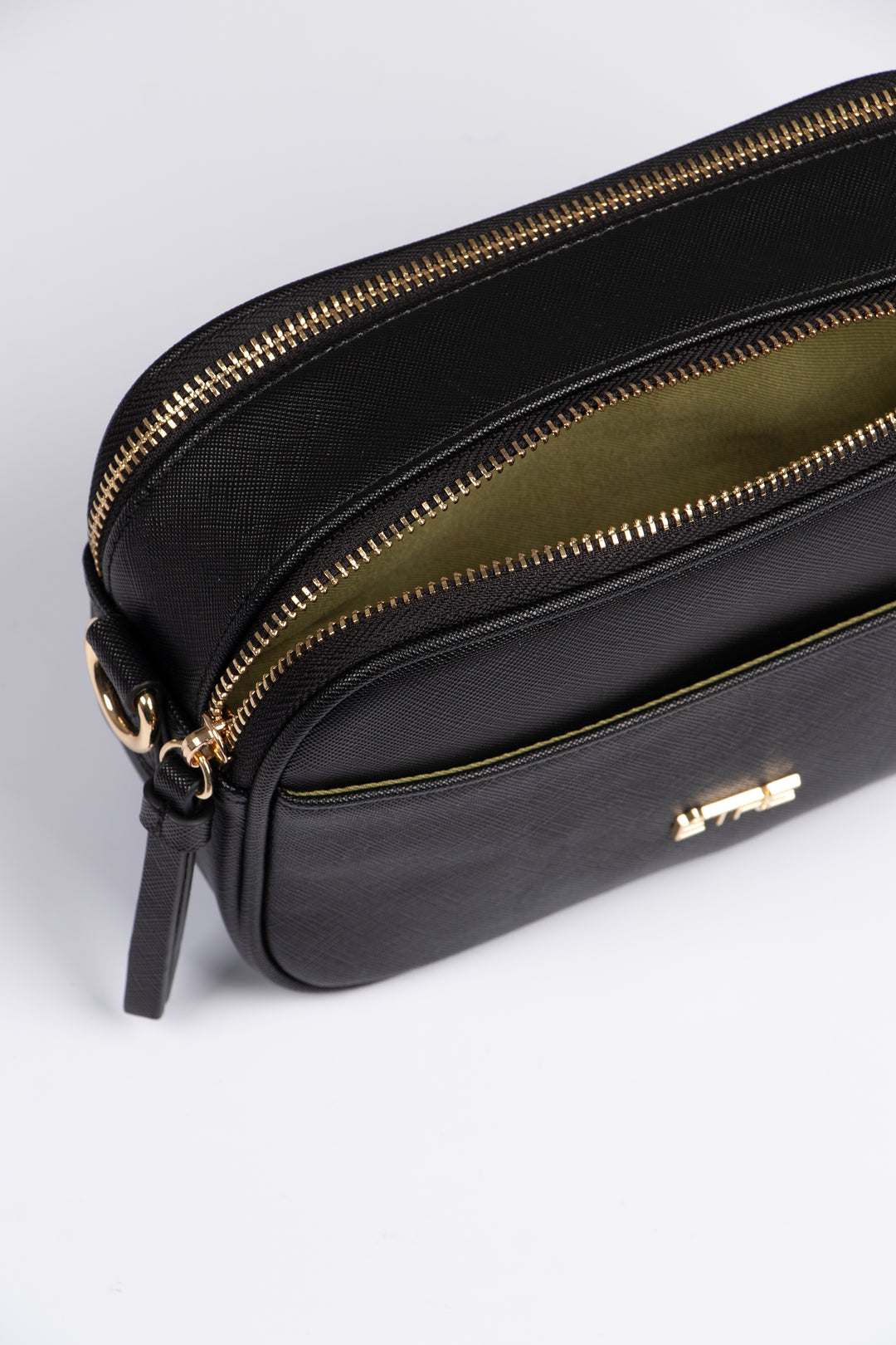 close up of the crossbody bag, showing two zip closing compartments on the top of the bag and one front pocket