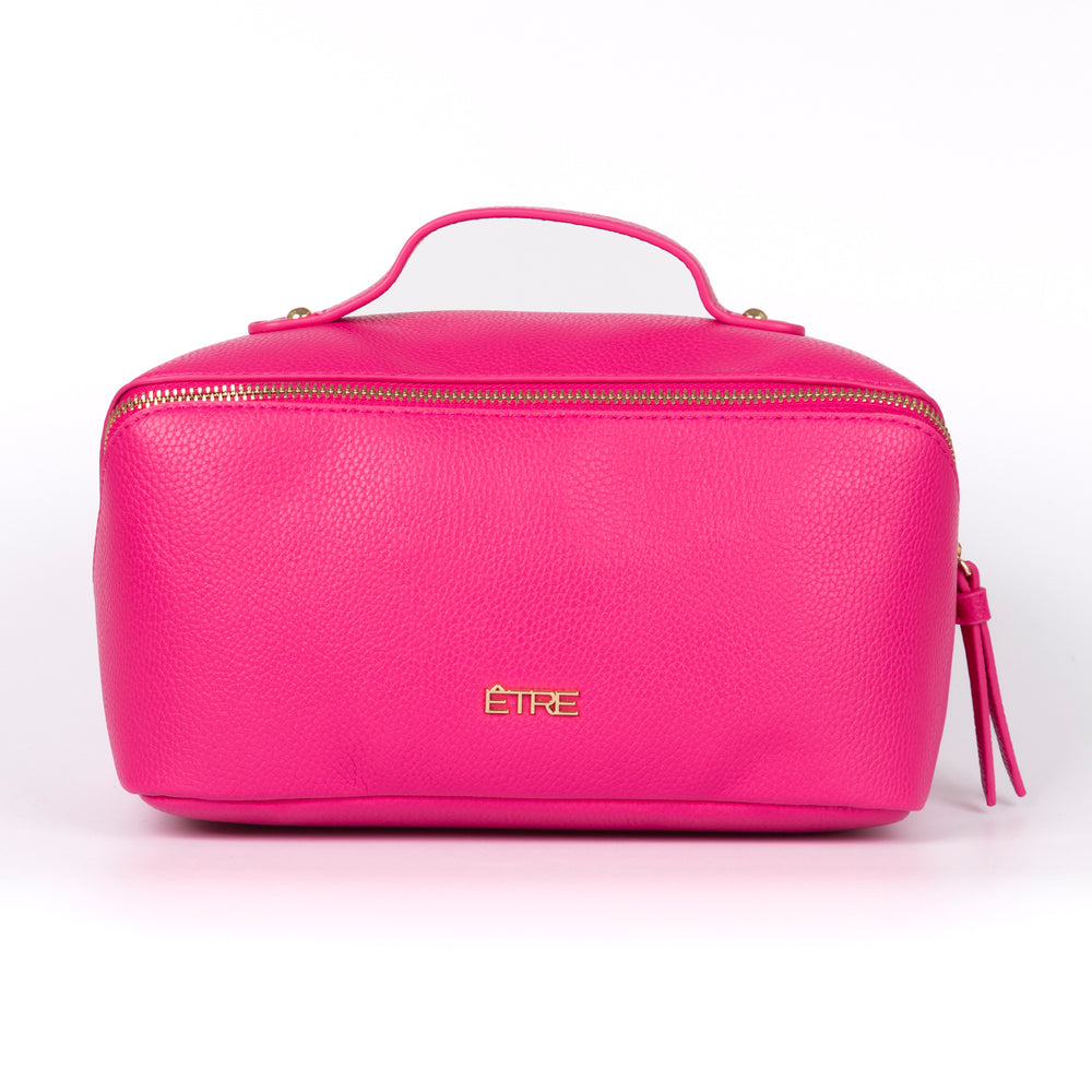 fuchsia pink faux leather vanity case with a top handle. the cosmetics bag has zip fastening closure.