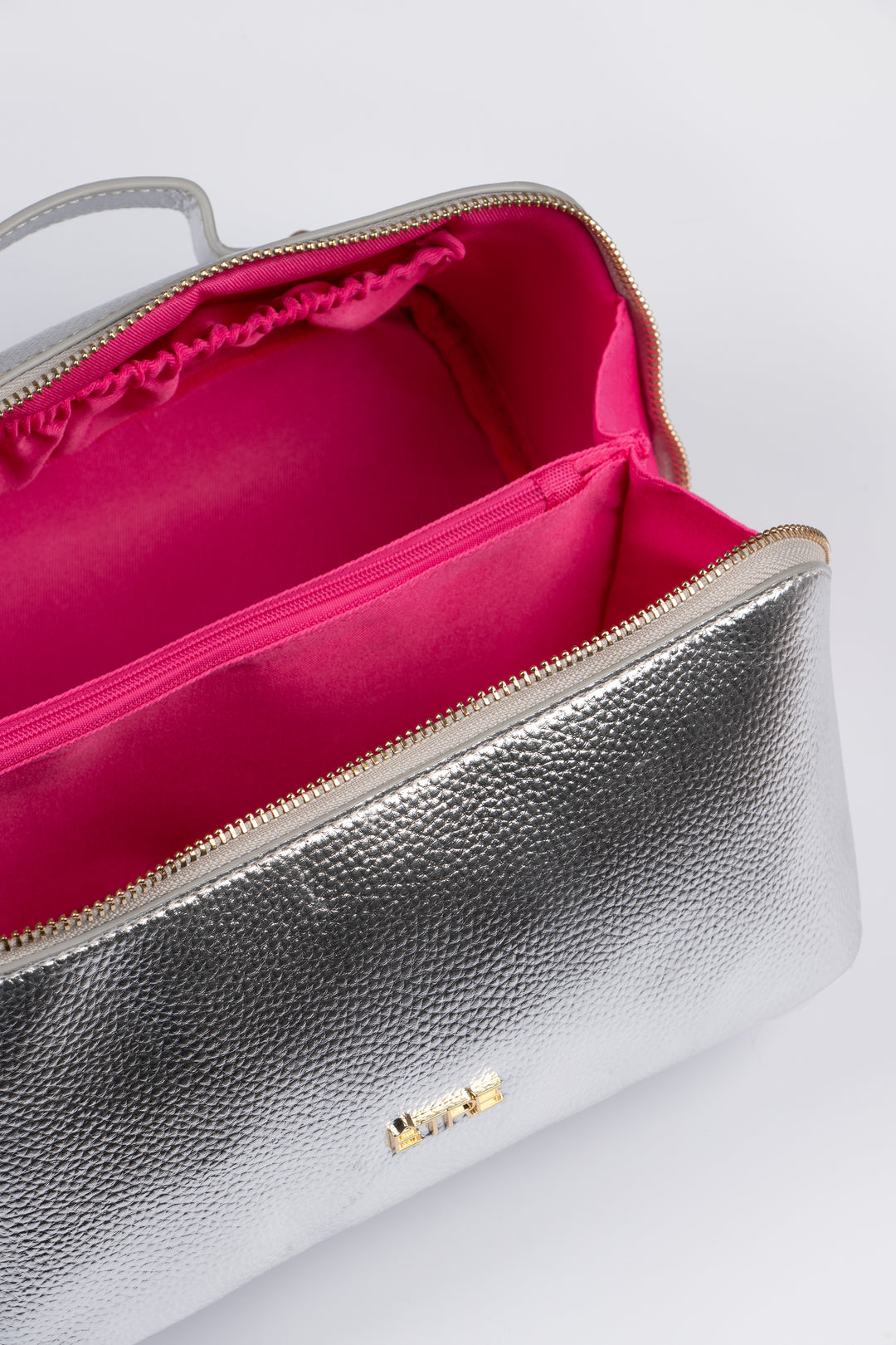 showing the vanity case open, there is a large main storage compartment with open pockets on one side, for storage. There is also an internal zip closure pocket.