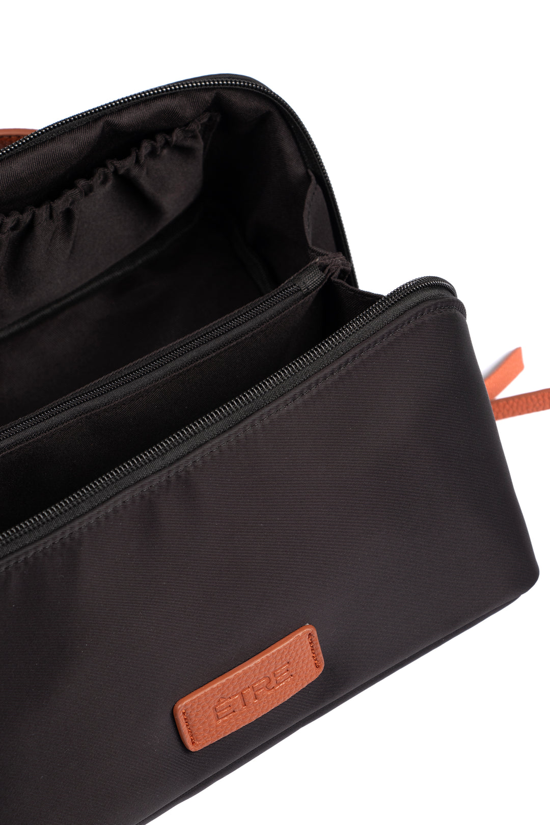 showing the vanity case open, there is a large main storage compartment with open pockets on one side, for storage. There is also an internal zip closure pocket.