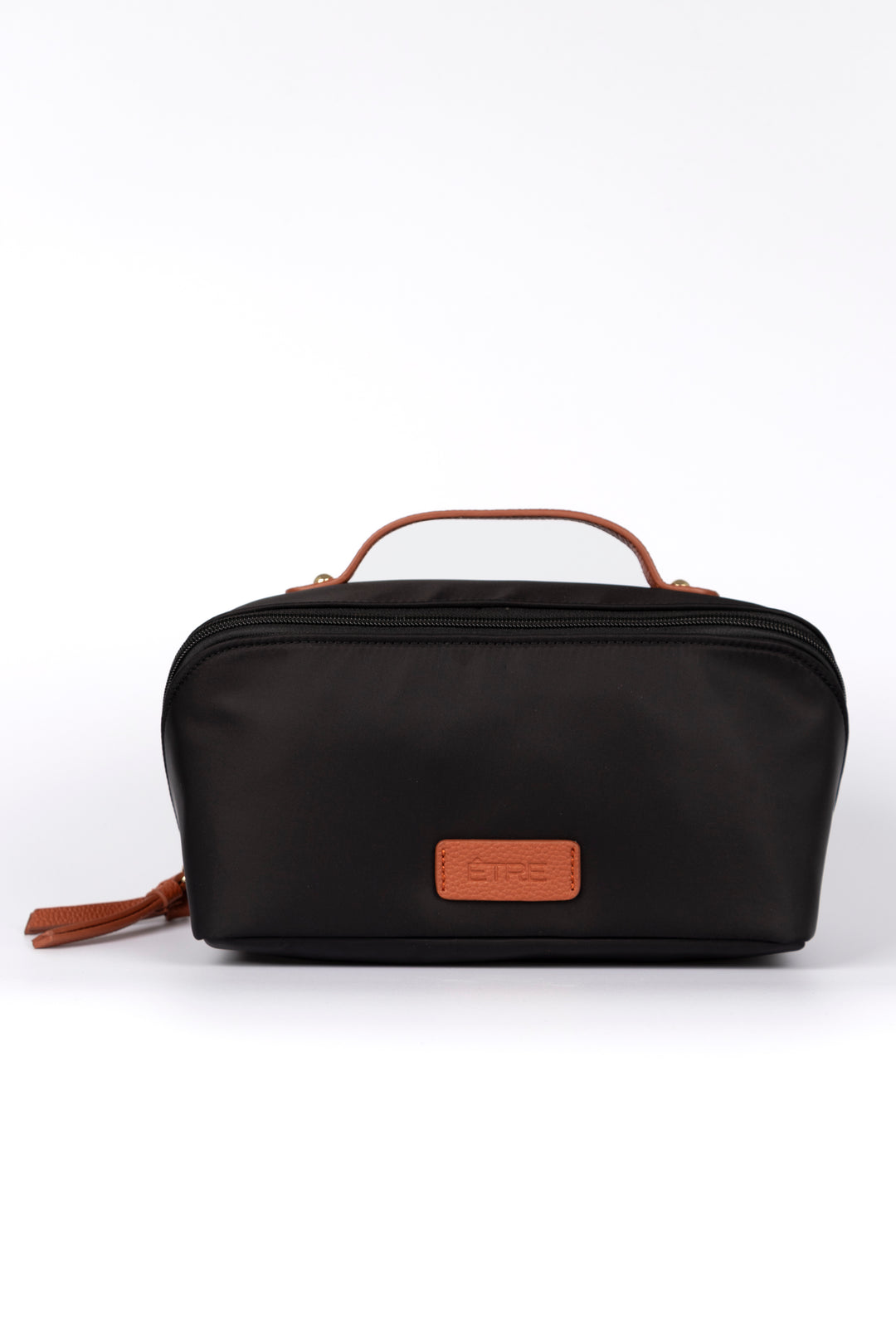 black vanity case with tan faux leather accents and top handle. the cosmetics bag has zip fastening closure.