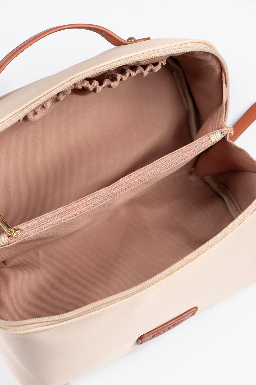 showing the vanity case open, there is a large main storage compartment with open pockets on one side, for storage. There is also an internal zip closure pocket.