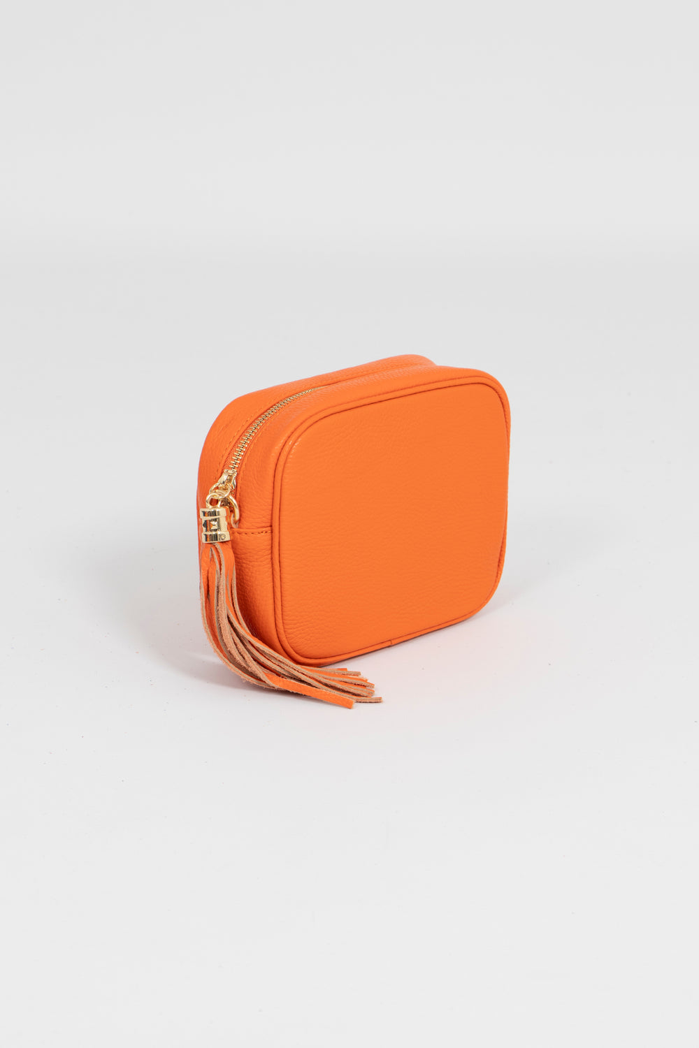 Close up showing zip closure of the pebbled orange leather crossbody camera bag