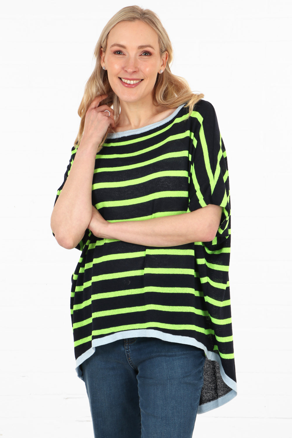 model wearing a navy and neon green striped batwing jumper, the sleeves are elbow length