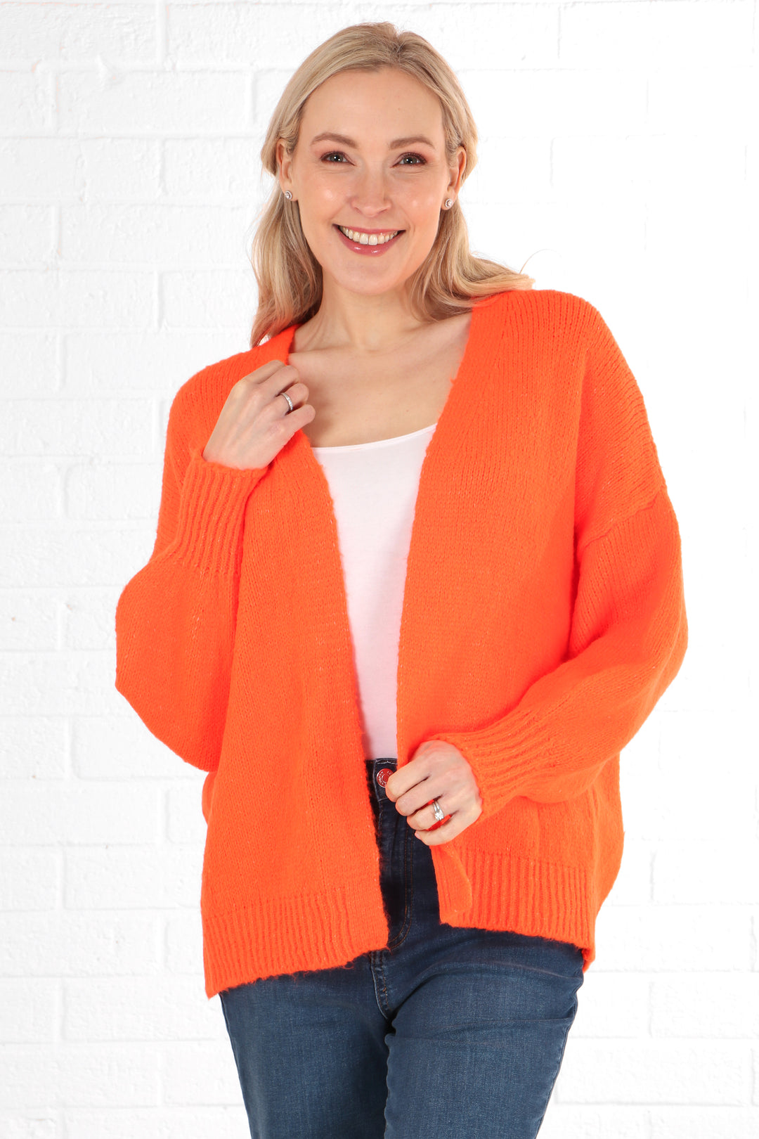 model wearing a plain open front orange cardigan with long sleeves