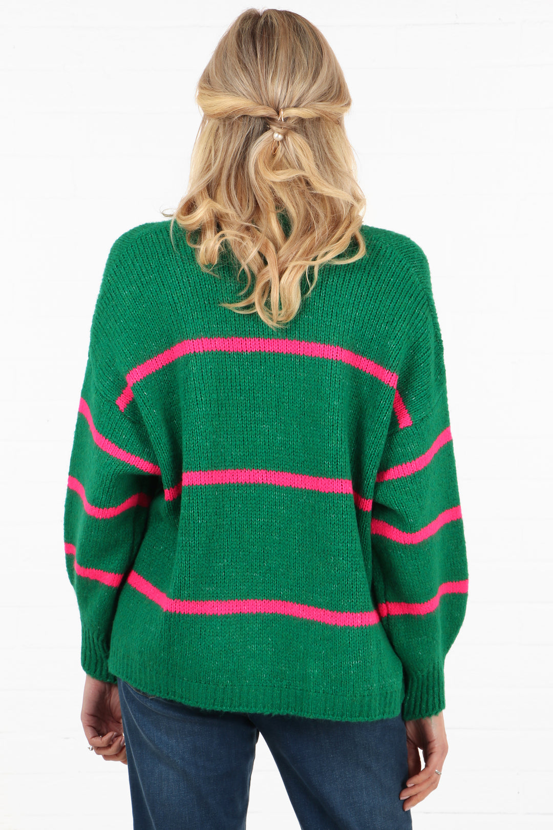 model showing the back of the green cardigan with the three fuchsia stripes