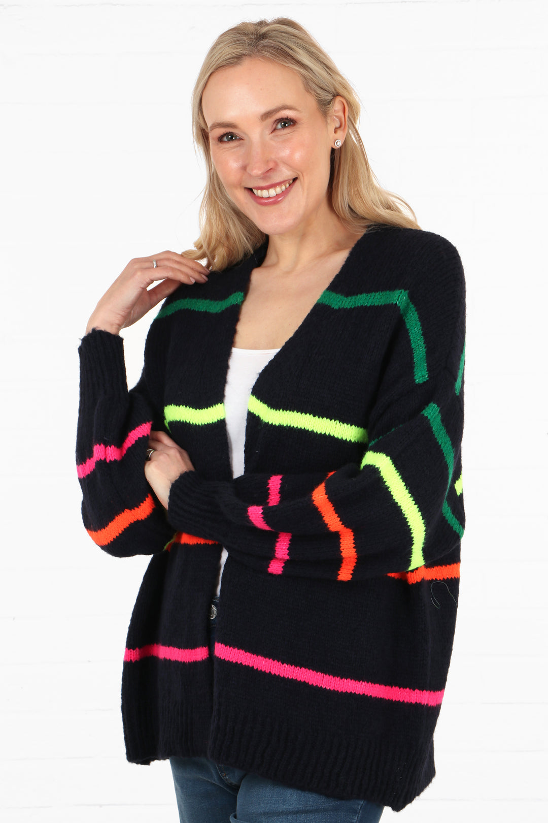 model showing a side view of the cardigan, showing that the sleeves also have stripes on them