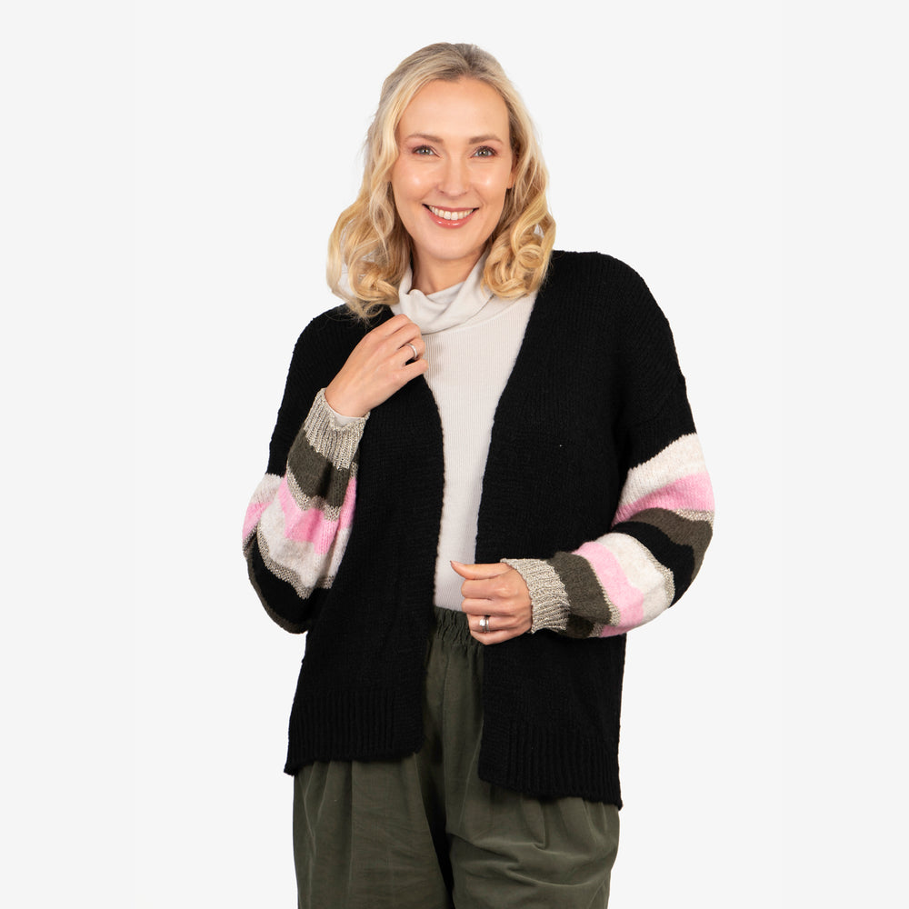 model wearing an open front black cardigan with pink, khaki and gold glitter striped balloon sleeves. the cardigan in open front and hangs on the hips