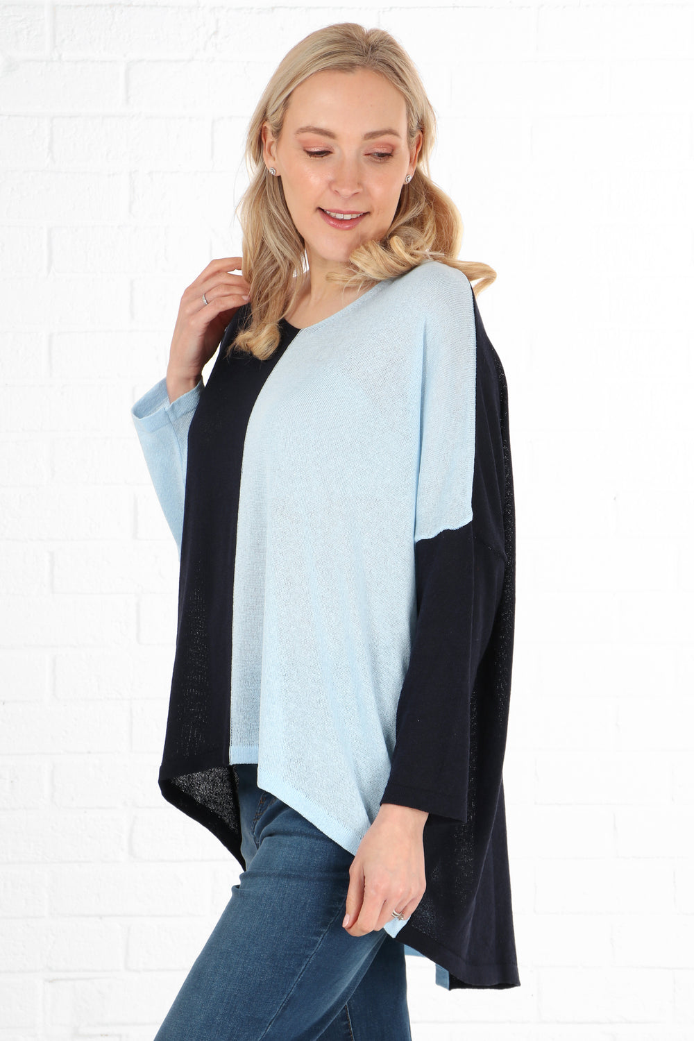 model showing a side view of the dip hem jumper, showing that the back is longer than the front