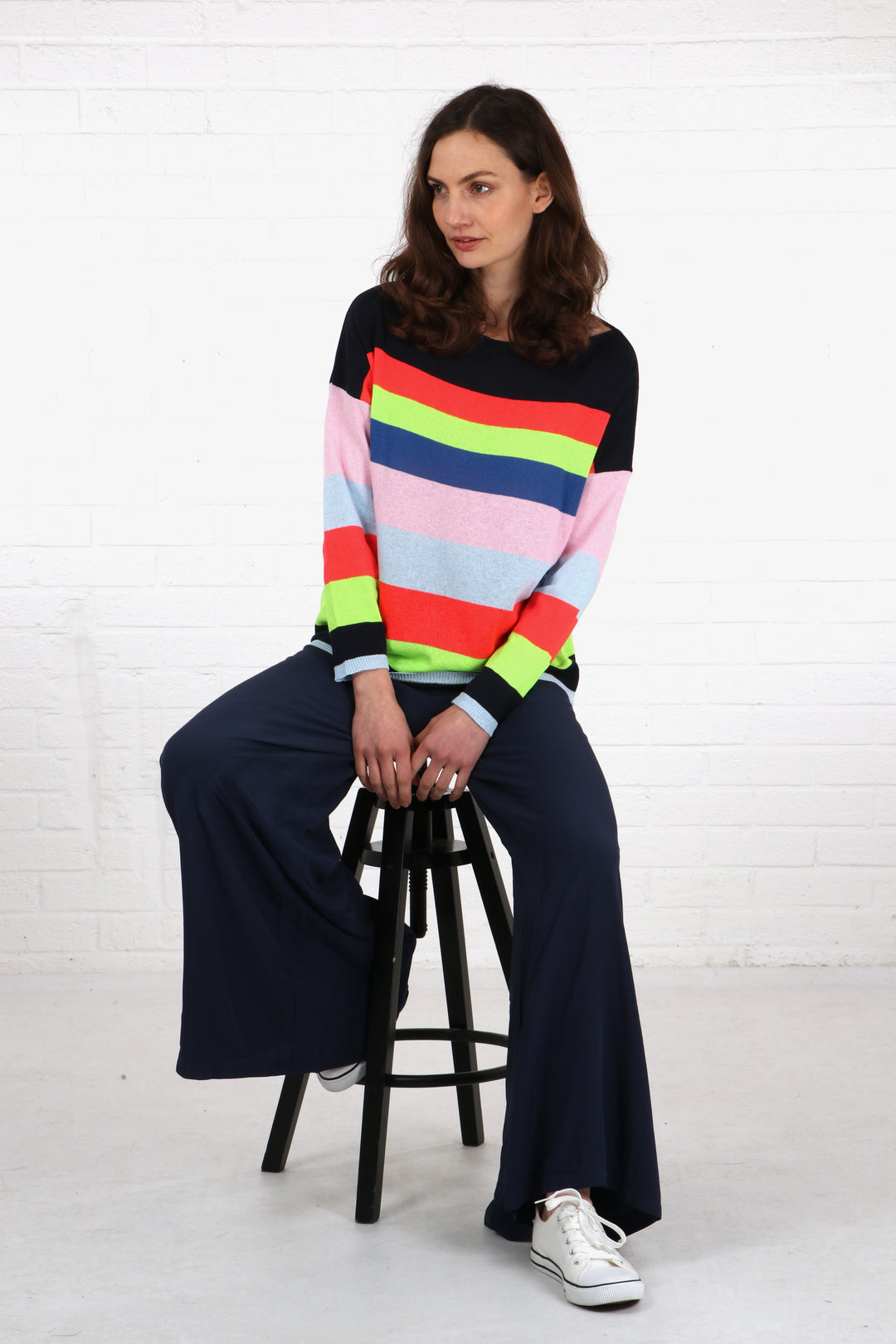 model wearing a pair of wide leg navy blue palazzo trousers with a colourful jumper