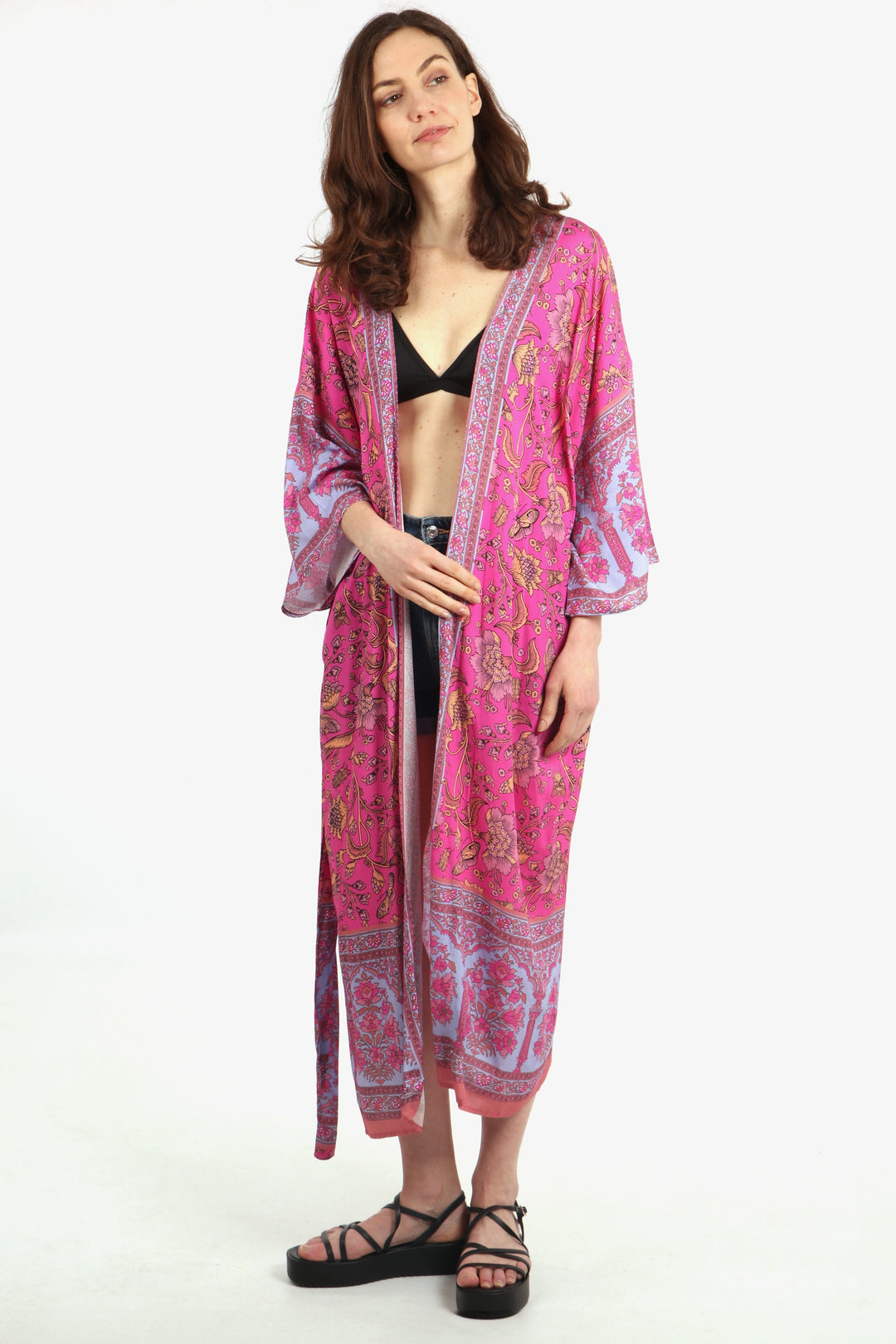 model wearing a long pink kimono robe with an all over vintage floral and butterfly print pattern