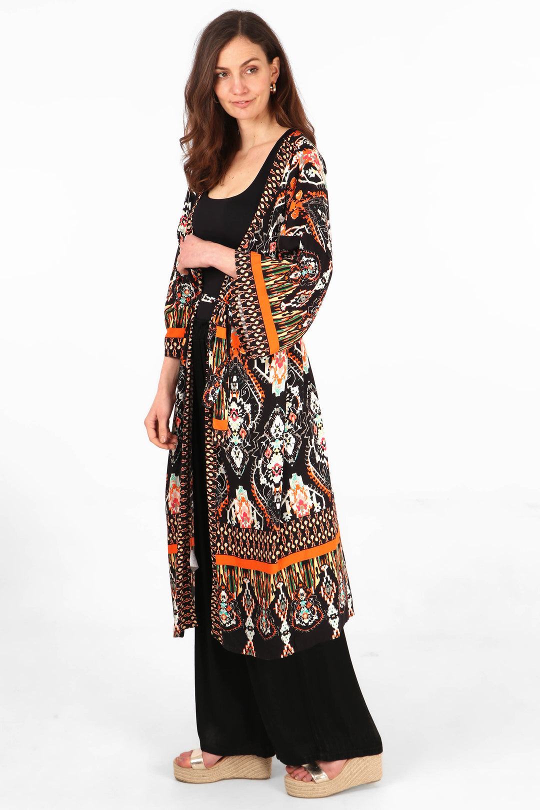 model wearing an ornate black and orange mandala print midi length kimono robe