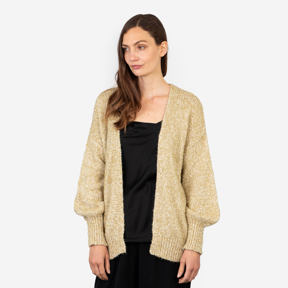 model wearing an open front gold sparkly cardigan