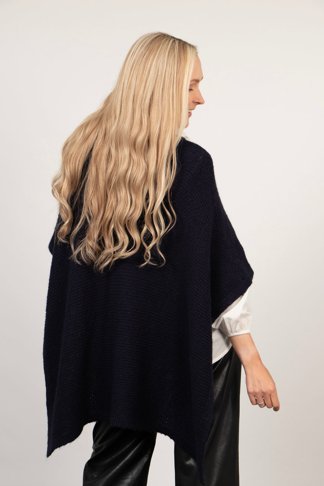 showing the back of the loose fitting navy blue tuck through wrap, showing the asymmetrical hemline