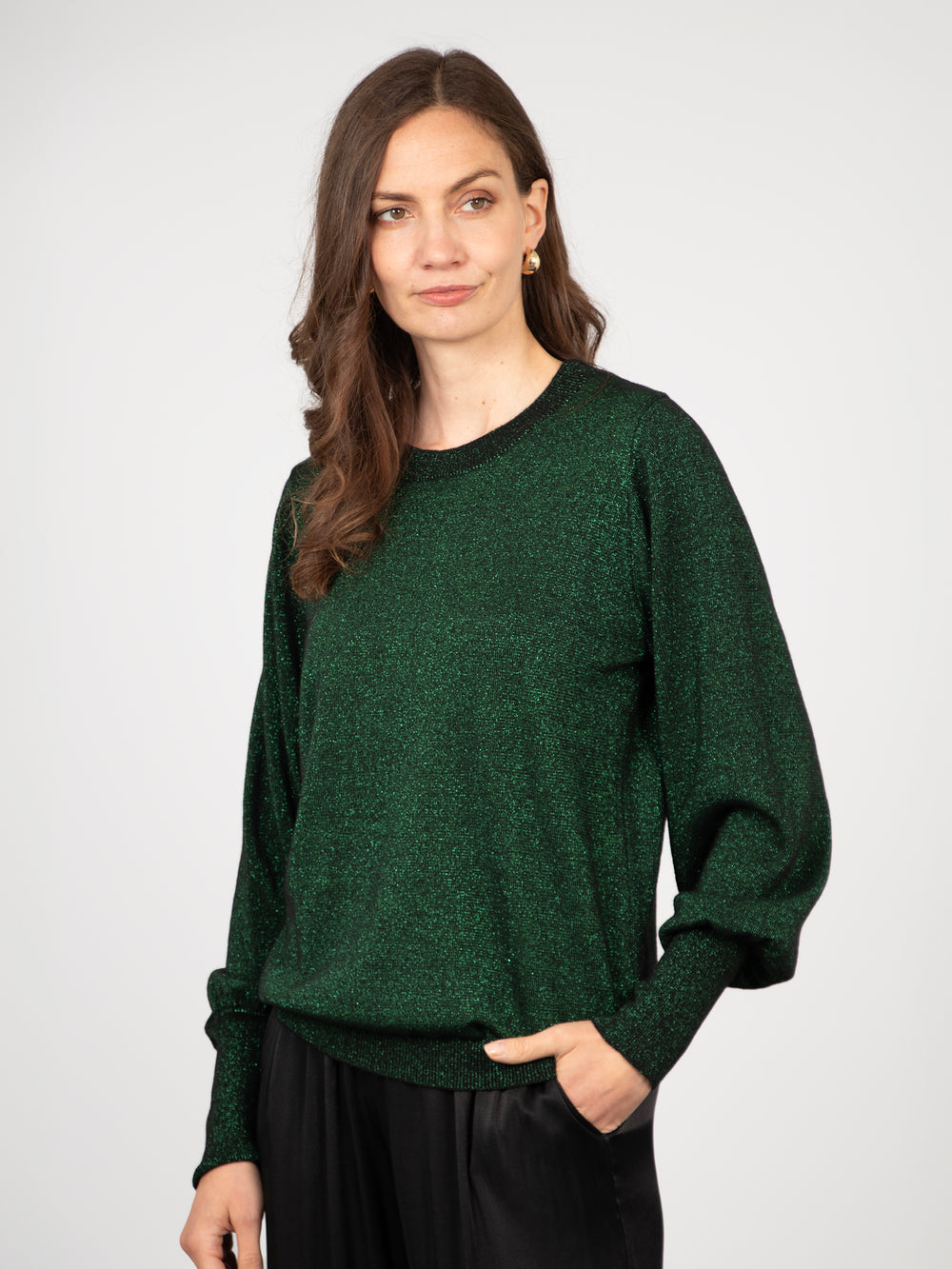 model wearing a long sleeve green sparkly jumper with an all over sparkle and a round neck