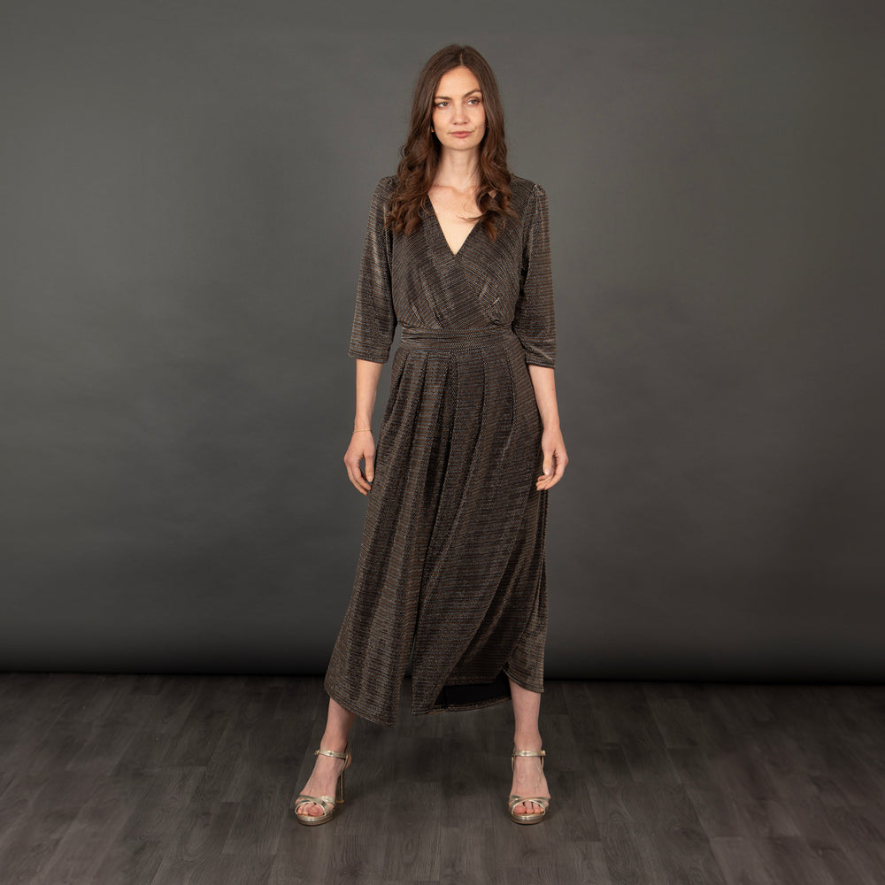 model wearing a black and gold retro glitter jumpsuit with cropped sleeves and a v-neck