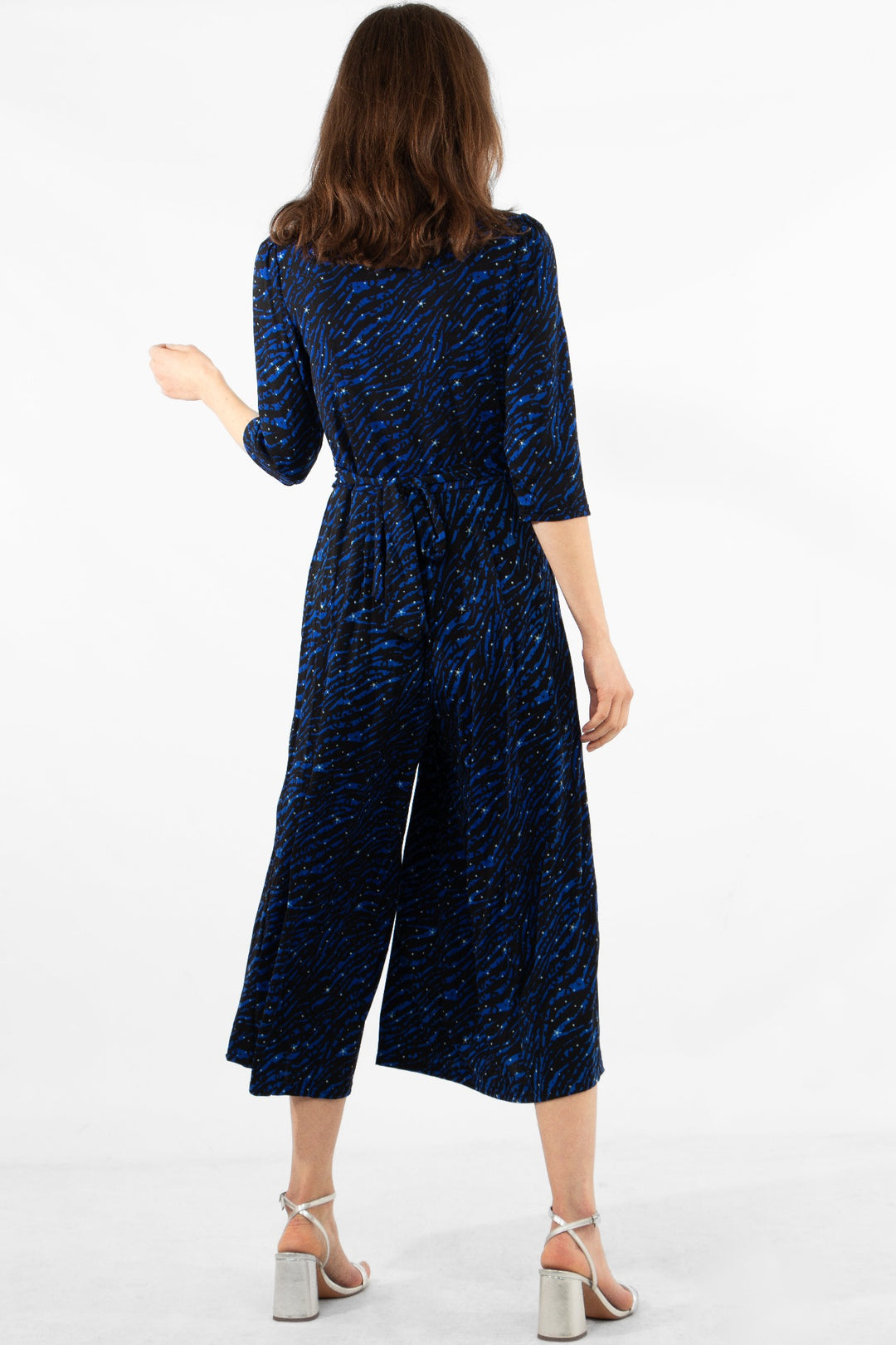 Model showing the back of royal blue zebra and star jumpsuit with tie back