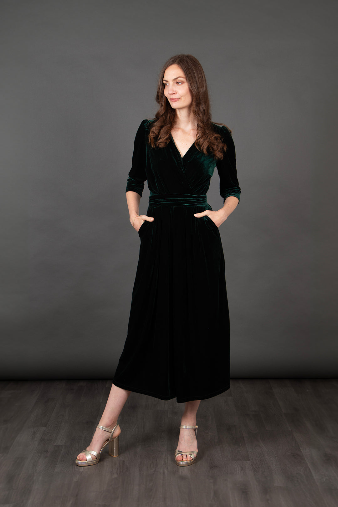 model showing that the green velvet jumpsuit has front pockets