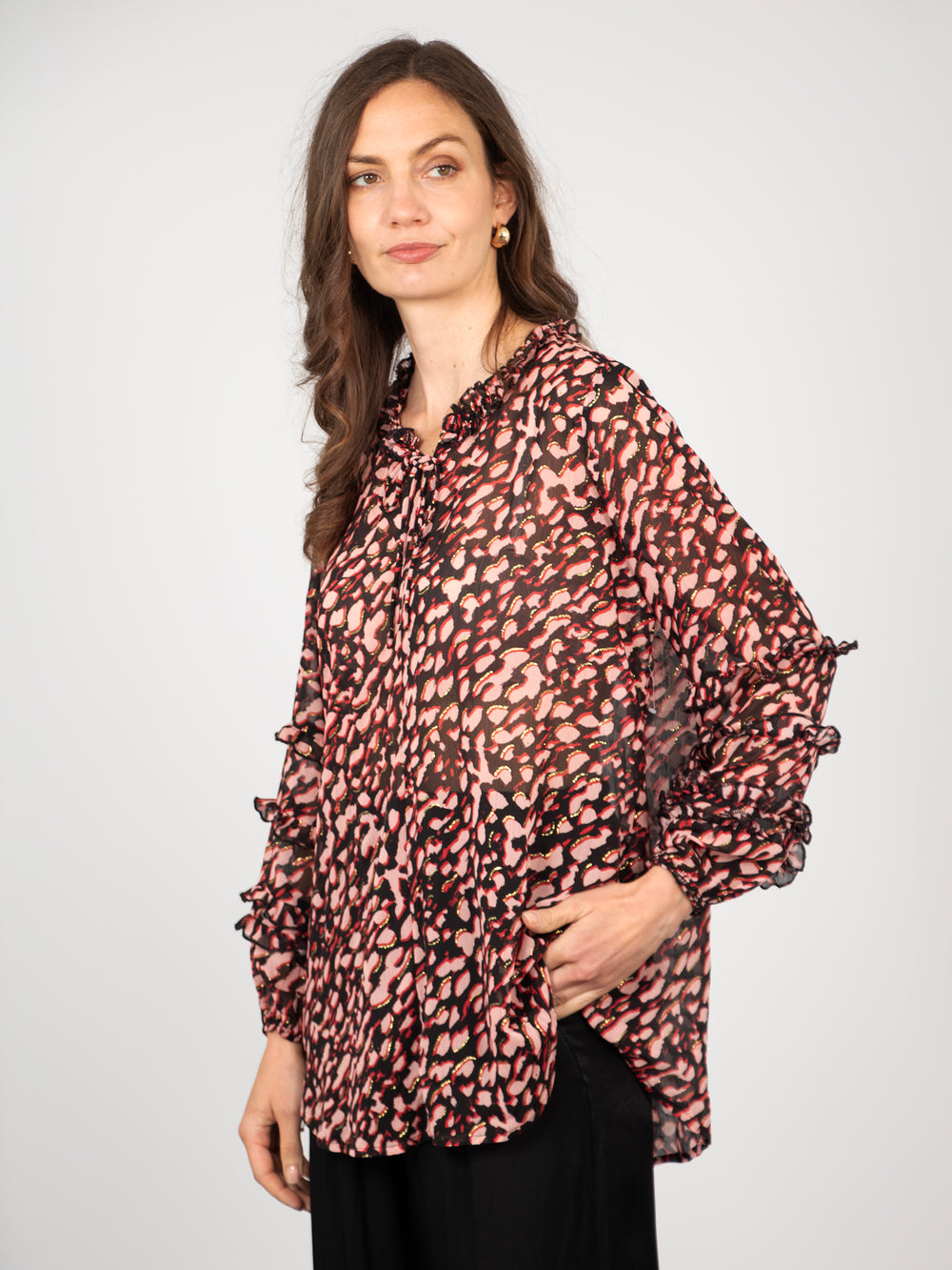 model wearing a pink chiffon leopard print blouse with long frilly sleeves