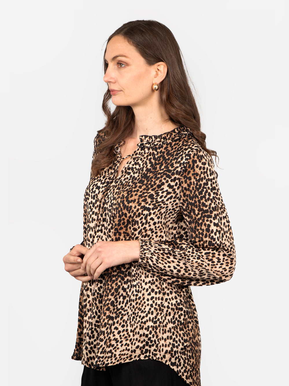 model wearing a neutral leopard print long sleeve blouse with a front neck tie and dipped hem