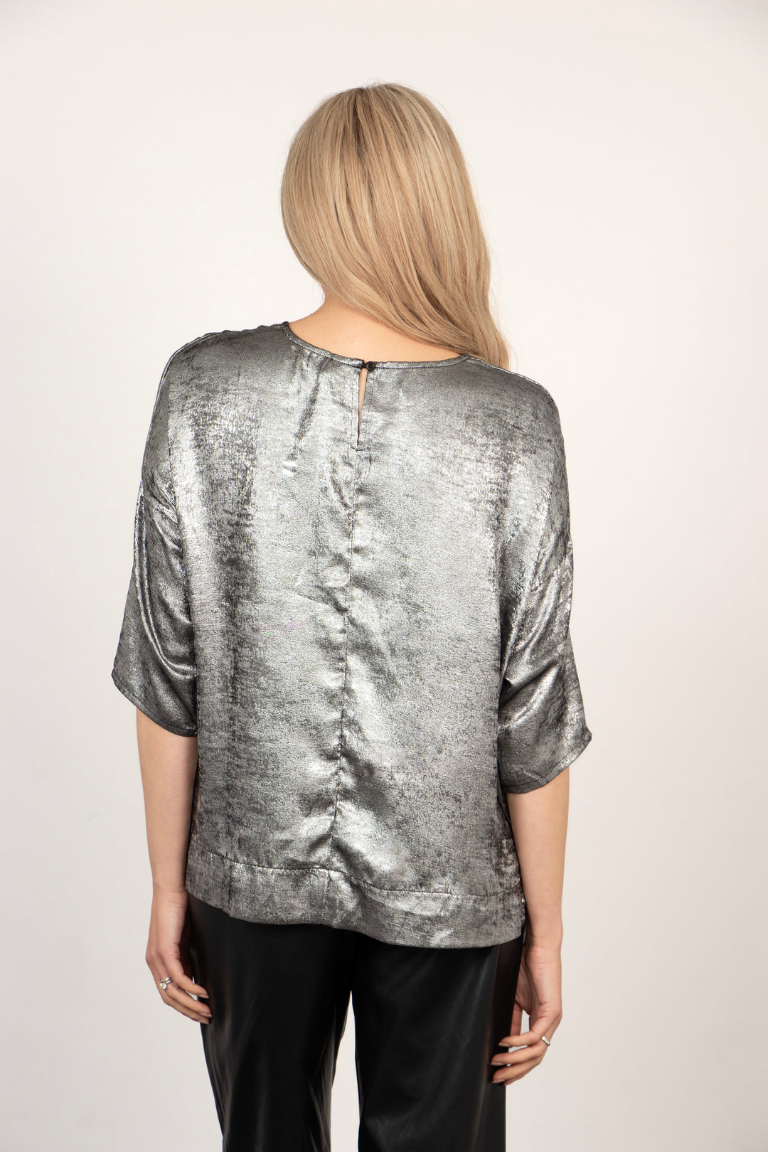 model showing the back of the top, there is a button fastening at the top of the neck.