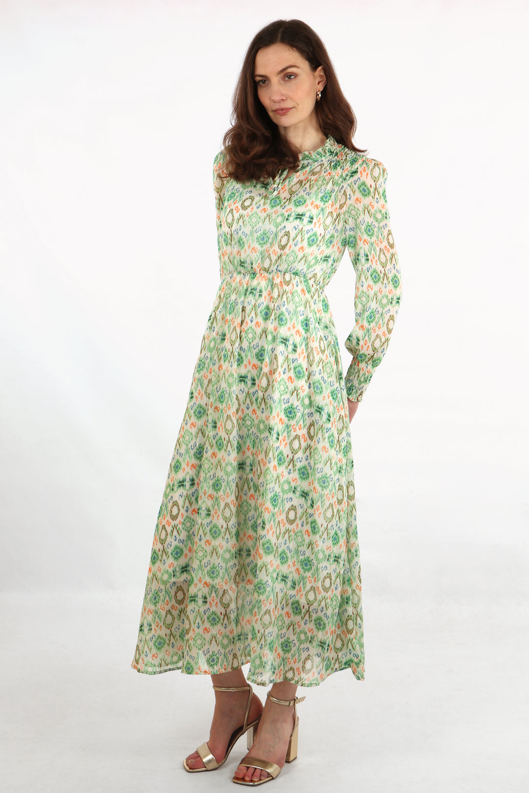 model wearing a long sleeve mdid dress with an all over green and orange ikat print pattern