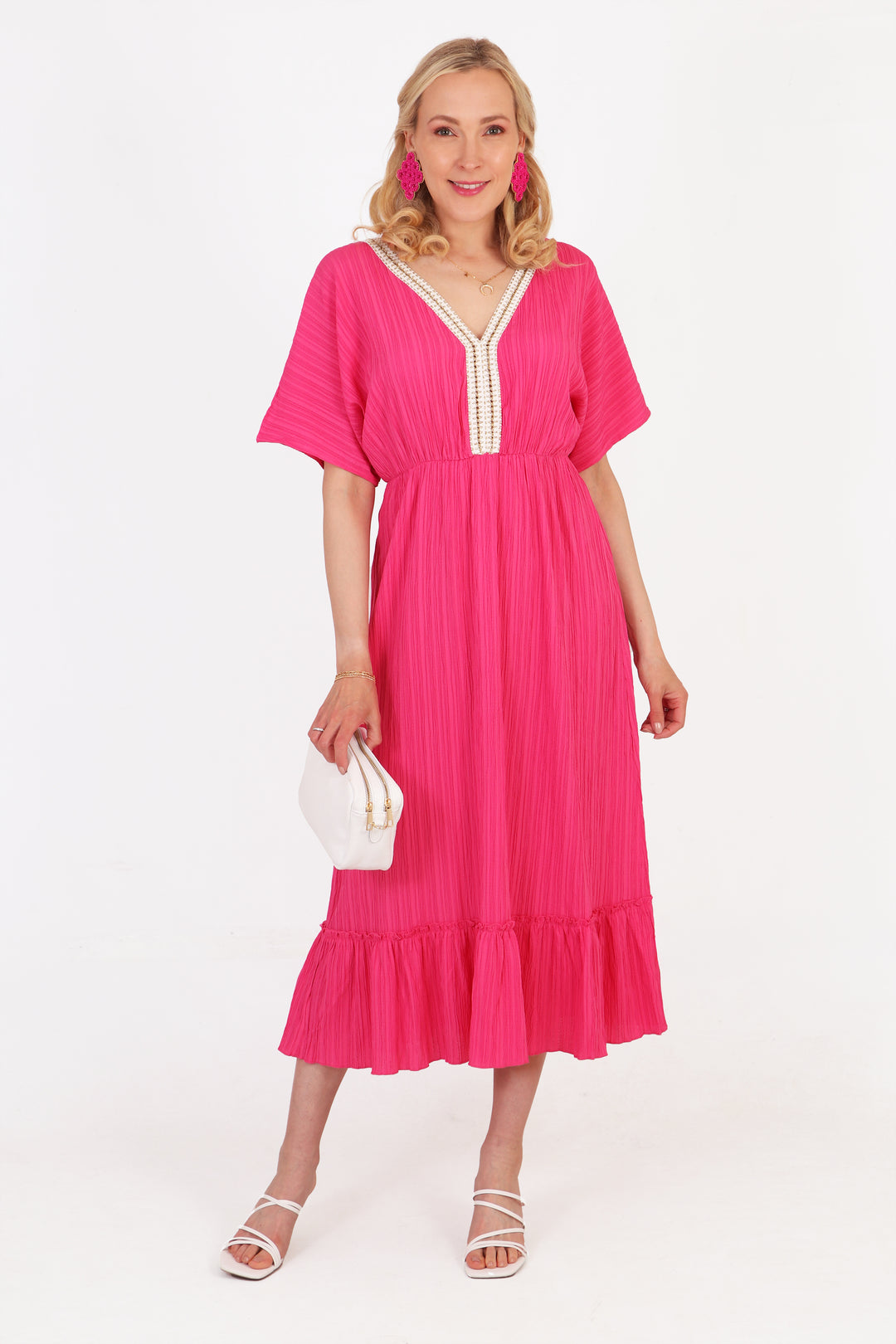 model wearing a fuchsia pink midi length kaftan dress with short sleeves and a tiered hem